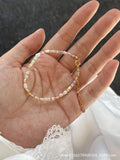 A women's bracelet and necklace set with irregular natural pearls and a 14K gilded purple finish.