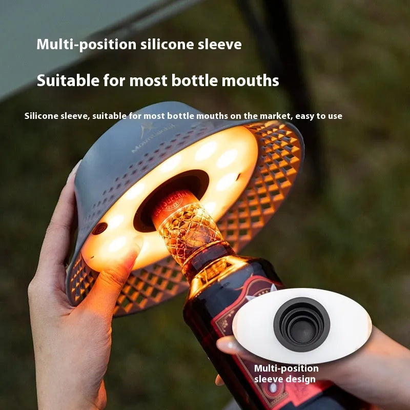 Beige wine bottle-shaped camping lantern with USB-C port and LED light on a wooden surface.