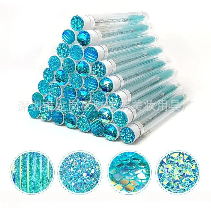 Set of coloured disposable mascara brushes inside clear plastic storage tubes on a white background.