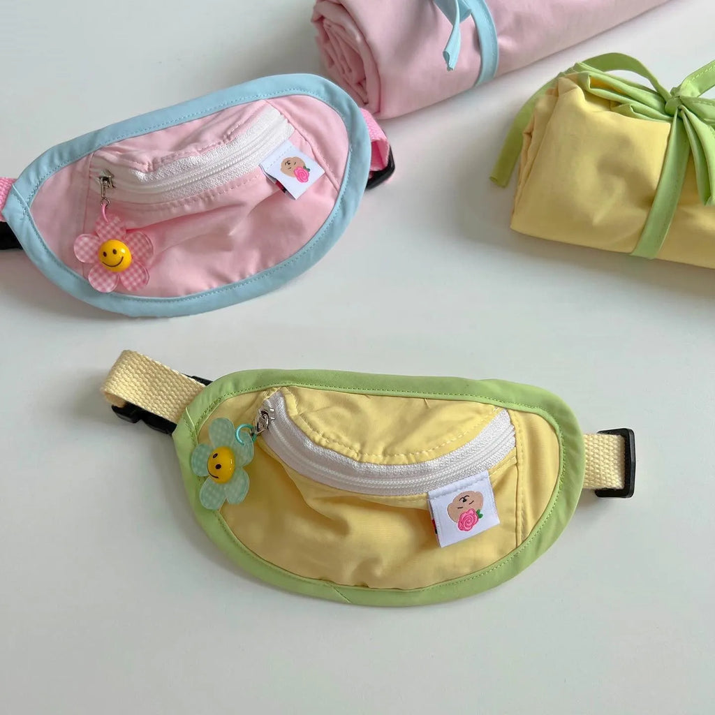 Pink and yellow messenger-style pet backpack for dogs and cats with poop bag feature