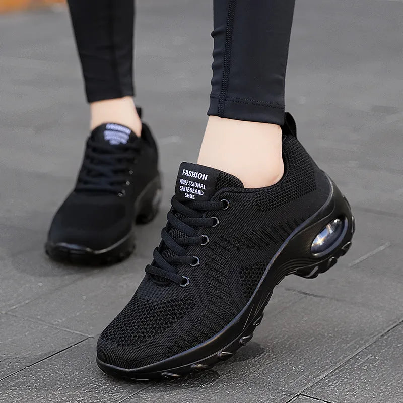 Women's round toe red and black mesh sneakers with front laces on a flat heel and textured PU sole.