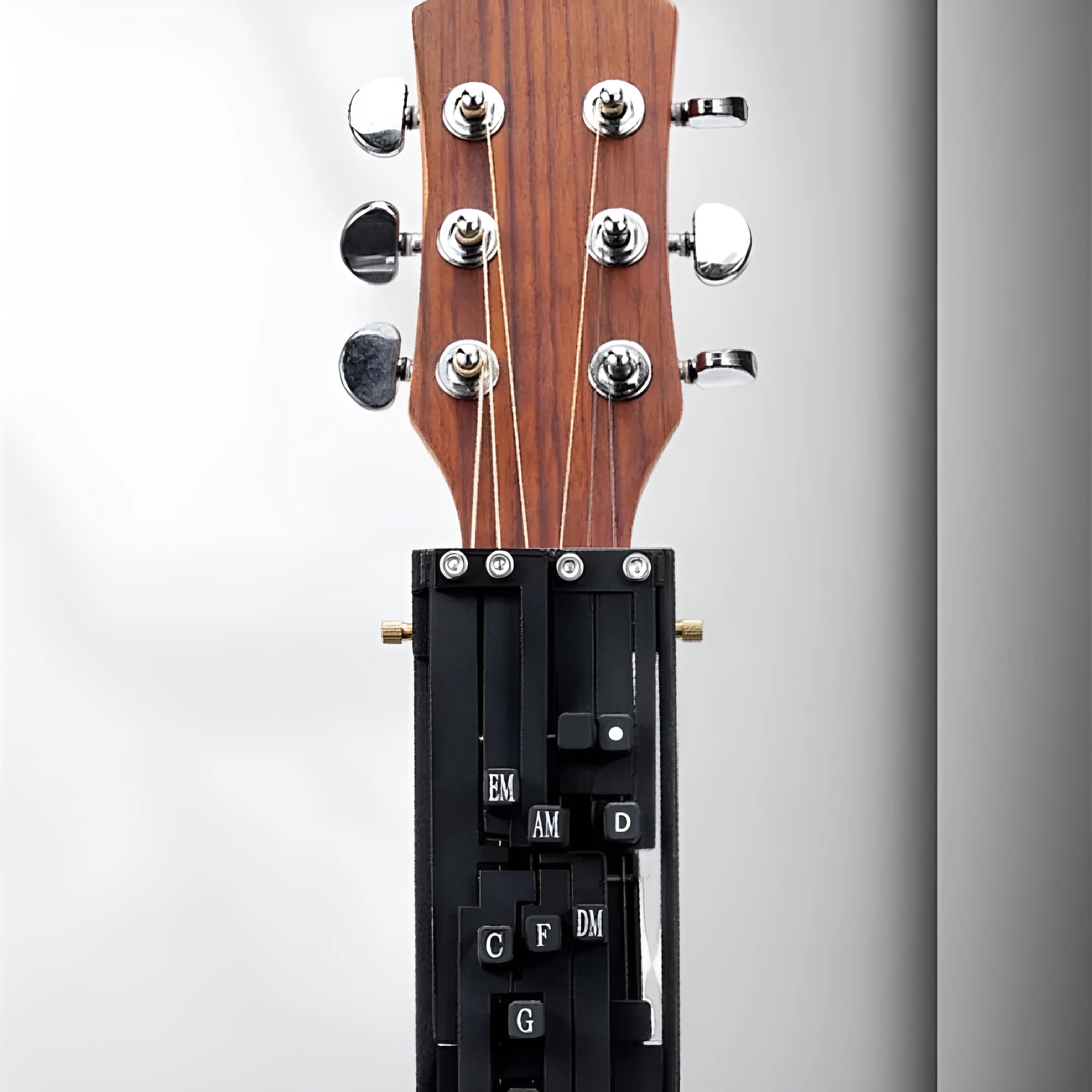 Black auxiliary guitar chord maker device with automatic gear for novice second chord practice.