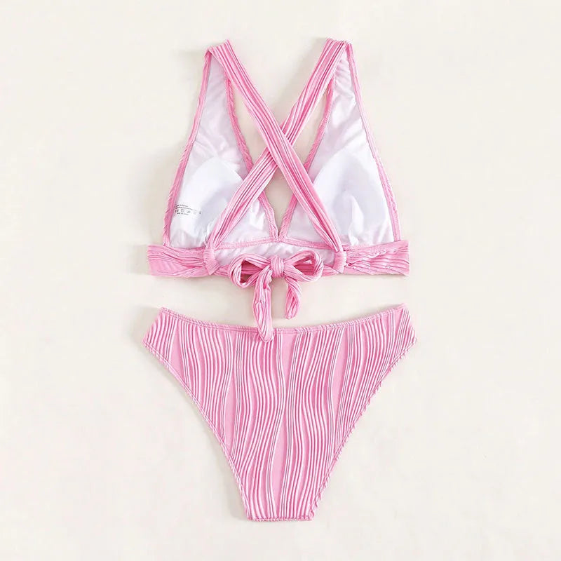 Women's pink halter strap bikini top and matching shorts on a neutral background.