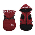 Red fleece-lined waterproof winter dog jacket with hood on medium-sized dog outdoors