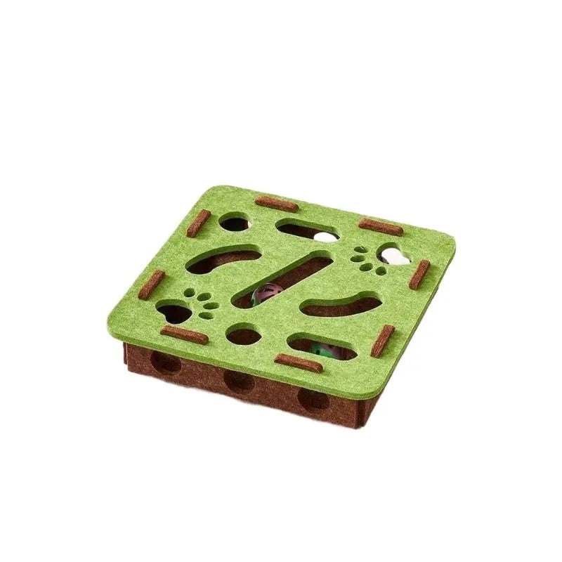 Square green brown felt cat puzzle box toy with a circular hole, shown next to a cat.