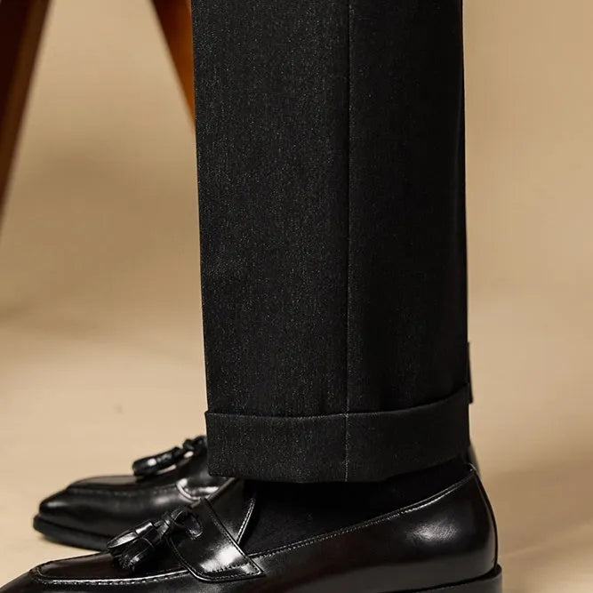 Men's black and brown polished leather tassel loafers for business casual wear, shown from the side.
