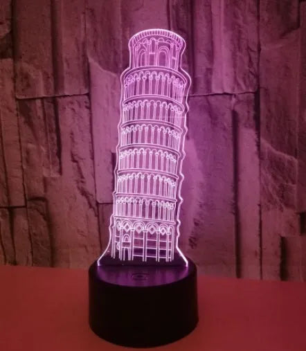 3D laser-cut Leaning Tower of Pisa nightlight glowing blue on a black base with a remote control.