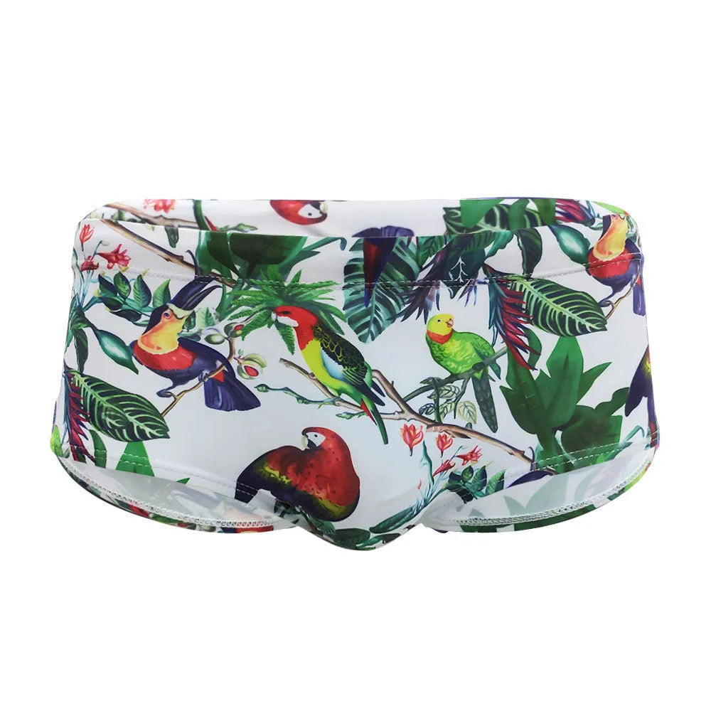 Men's blue swimming trunks with a detailed floral and bird print pattern, small boxer style