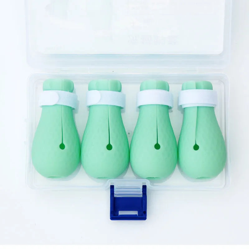 Set of four green silicone cat anti-scratch foot covers or gloves for pet care.