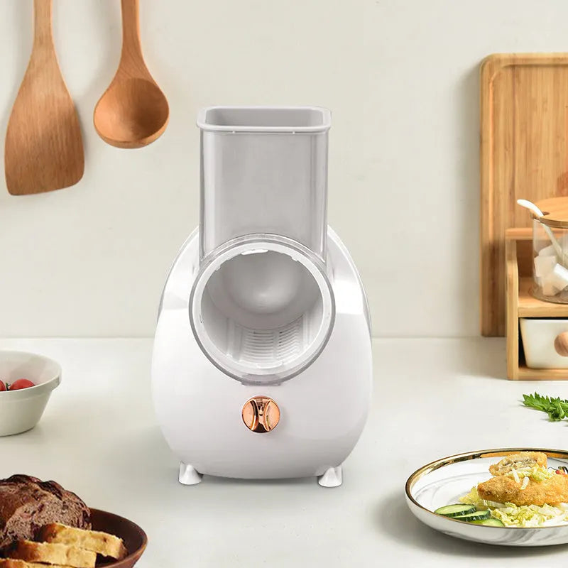 White electric vegetable slicer with rotary grater and suction base on a kitchen counter.