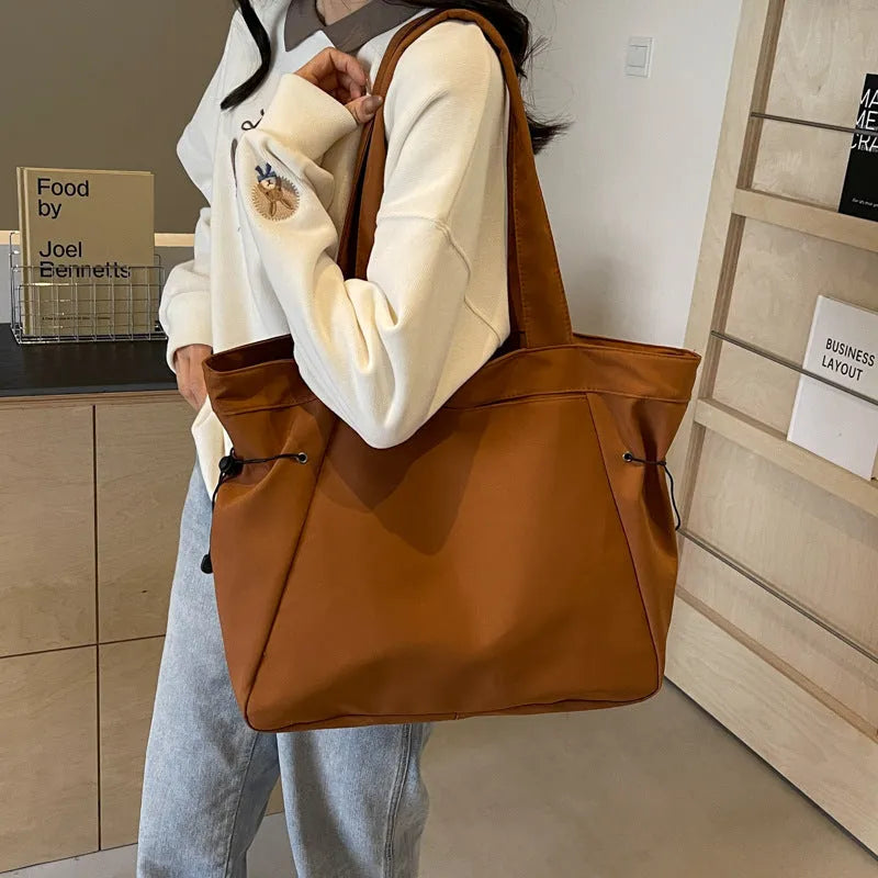 Soft foldable Oxford cloth shoulder tote bag in a street style, shown in various colours.