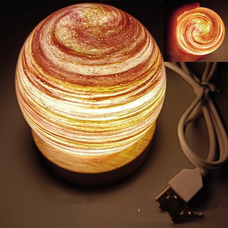 Modern planet-shaped USB night light with dimming on a desk.
