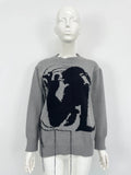 Grey women's alpaca wool sweater with abstract pattern and tassel detailing on a hanger.