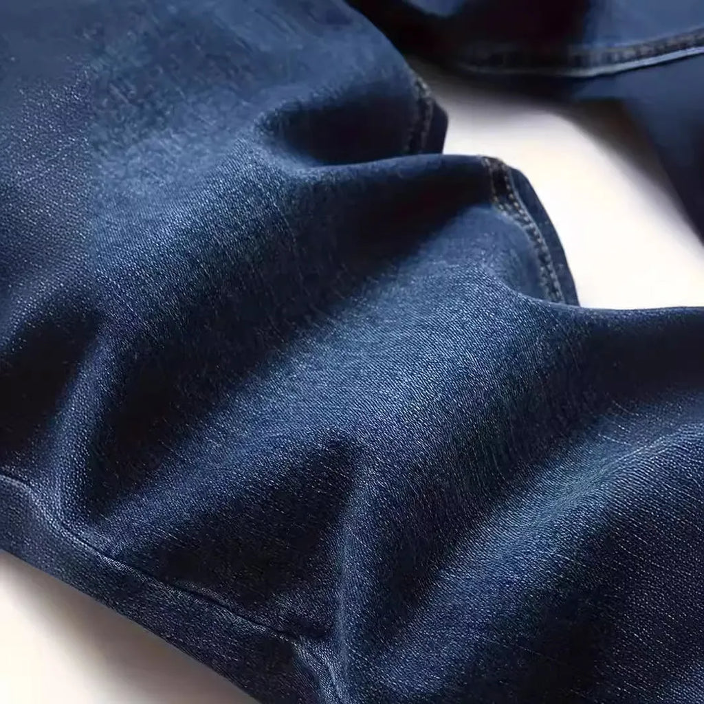 Dark blue men's slim-fit cotton jeans with a skinny leg opening on a plain background.