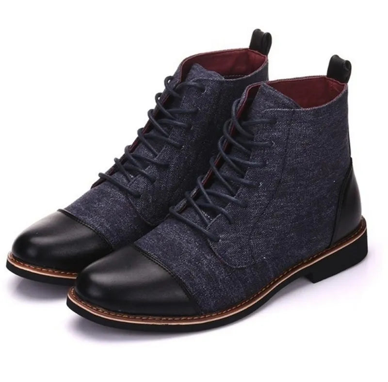 Men's black leather motorcycle ankle boots with side belt buckles and a thick rubber sole on a wooden floor.