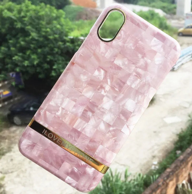 Plastic iPhone case with abstract marble pattern print in multiple colour options on a wooden table.