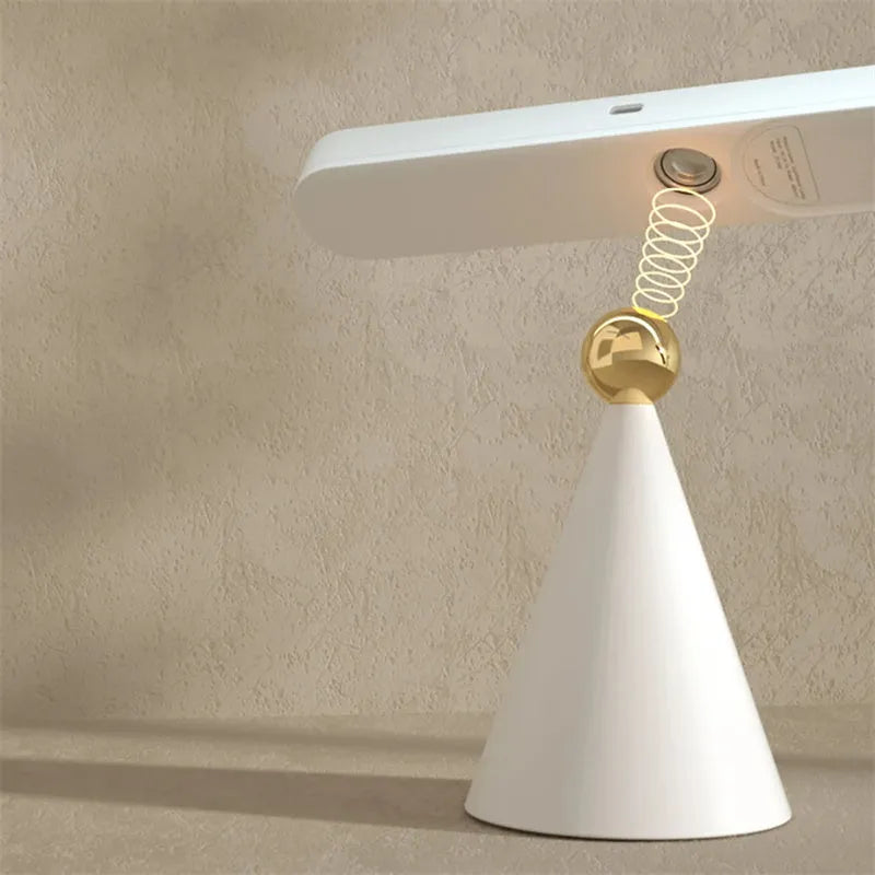 White geometric desk lamp with magnetic base mounted on a metal wall surface.