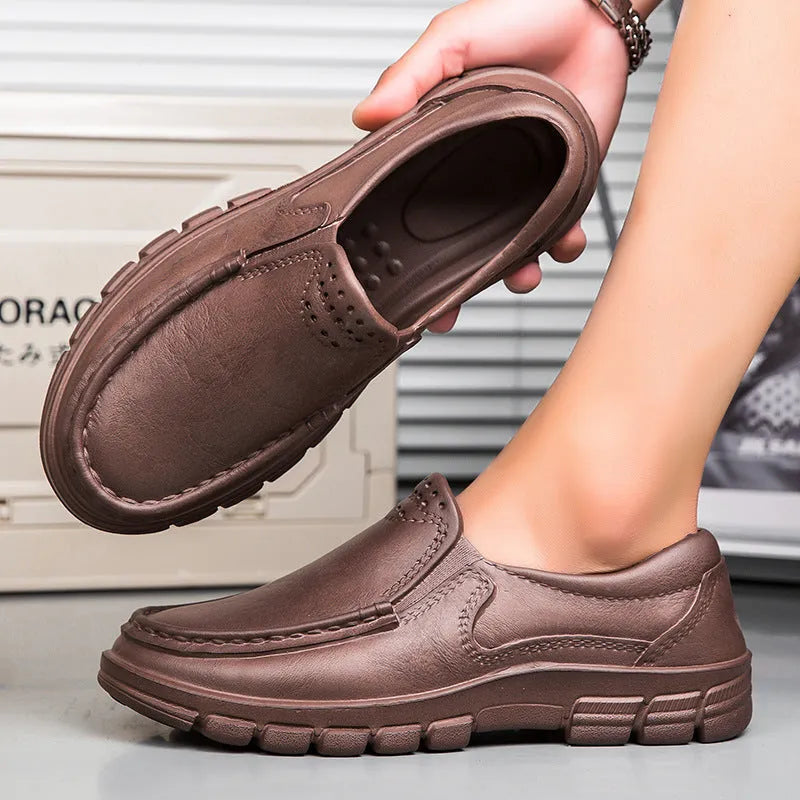 Men's black and brown slip-on work shoes with a waterproof platform and mid-top design.