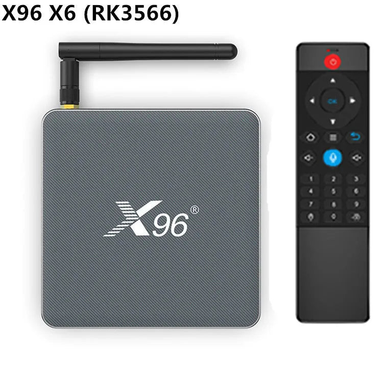 Android smart TV set-top box with voice remote control on a wooden table next to a television.