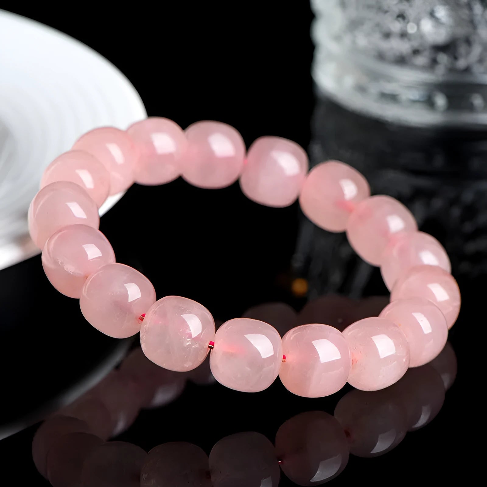 Close-up of a pink natural crystal bracelet with polished barrel-shaped beads measuring 8-10mm.