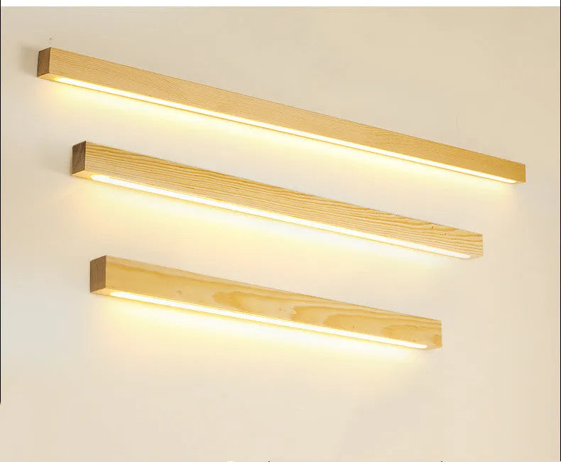 Walnut colour long wooden strip wall lamp with integrated LED lighting mounted on a wall.