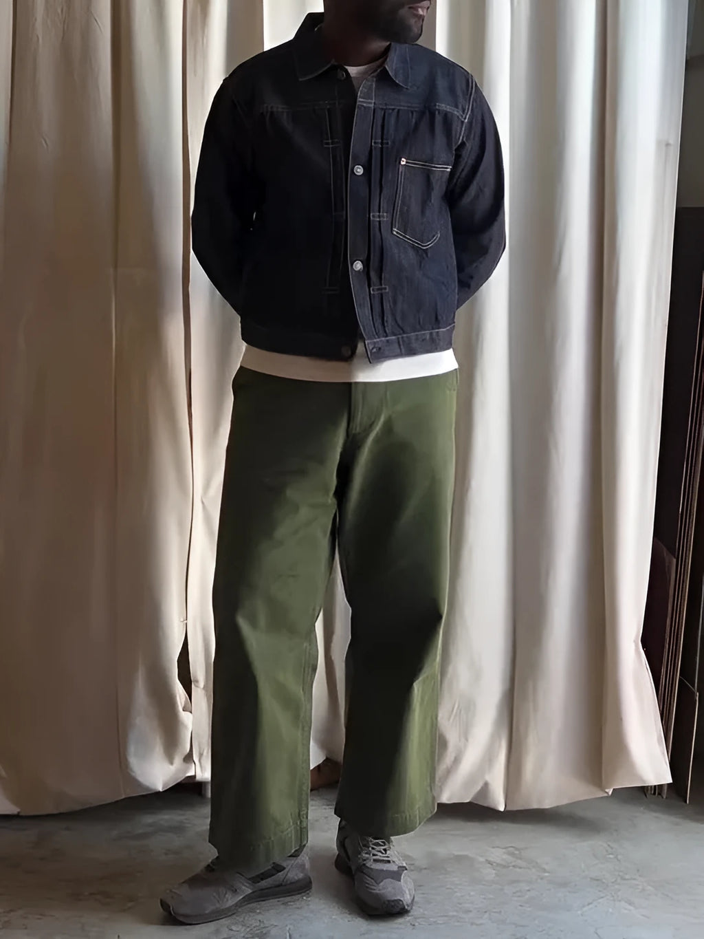 Dark blue denim button-up jacket with classic collar on a standard hanger