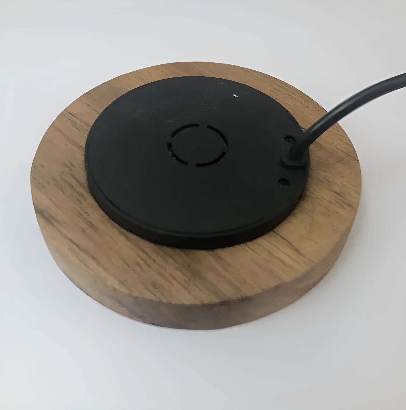 Black 60mm round wireless phone charging pad for furniture installation