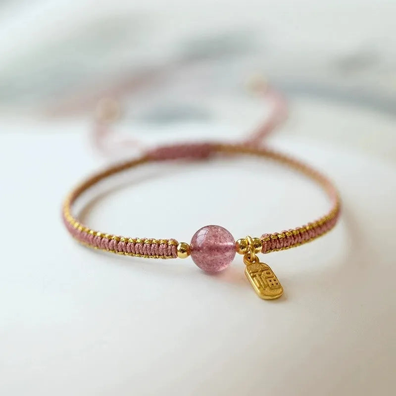 Adjustable red rope bracelet with a choice of Strawberry Quartz or Hetian Jade bead, showing the national style design.