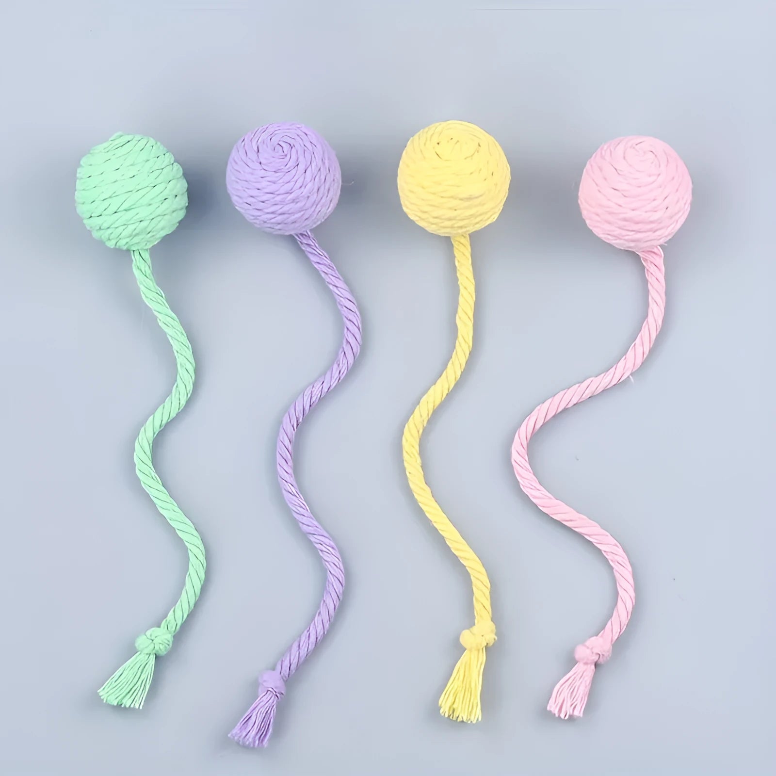 Colourful cat toy ball with an attached rope, shown in green, pink, purple, and yellow.