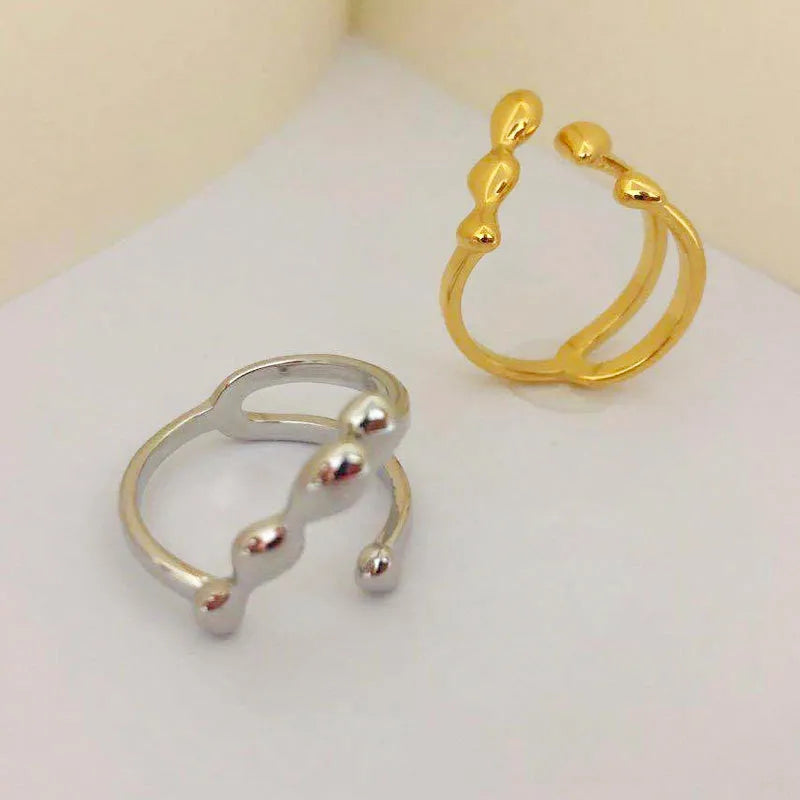 Brass spherical ring for women in gold or silver colour on a circular band.
