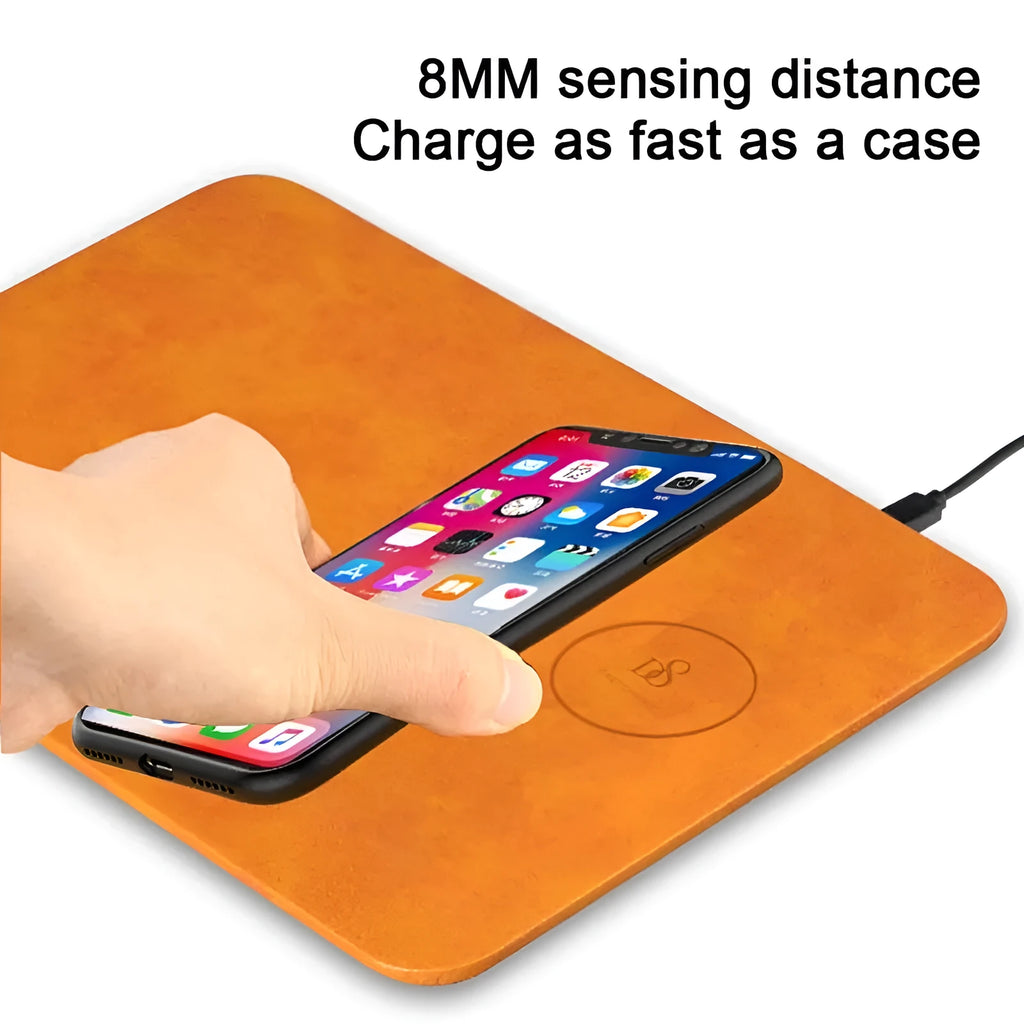 Brown PU leather wireless charging mouse pad with micro-USB cable on a wooden desk.
