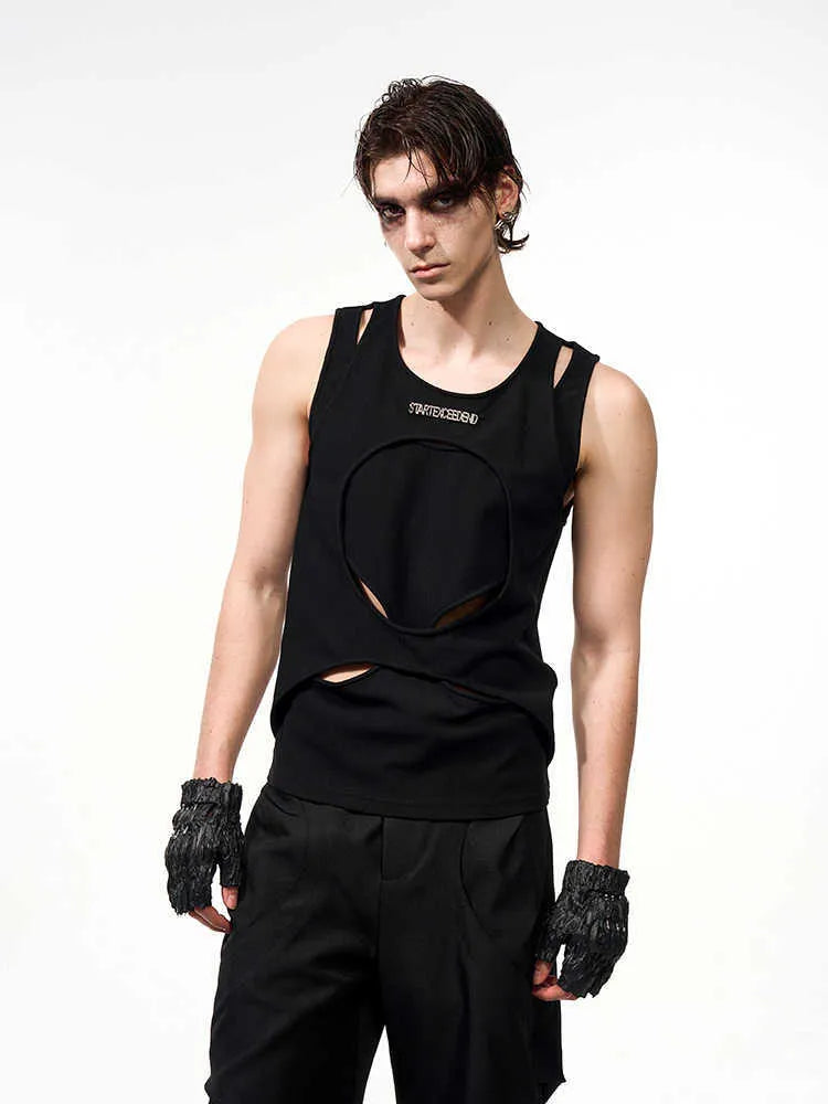 Man wearing a loose-fitting black sleeveless vest with a round neck, showcasing the hollow-knit fabric texture.