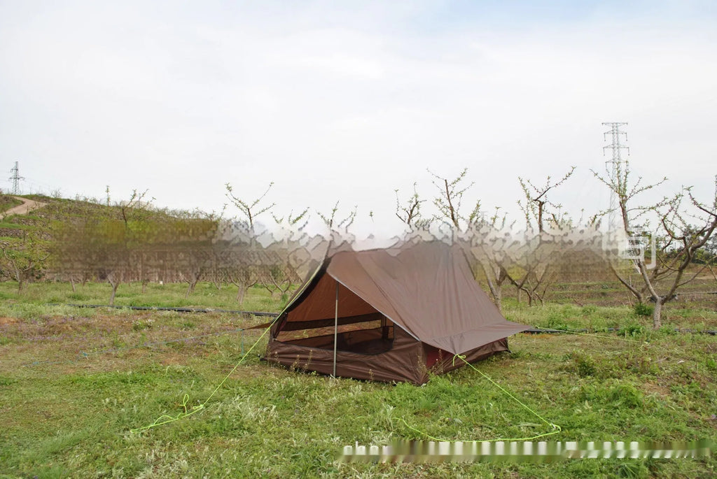 Brown and white pole-free A-line cabin tent for 2-3 people shown pitched with hiking poles.