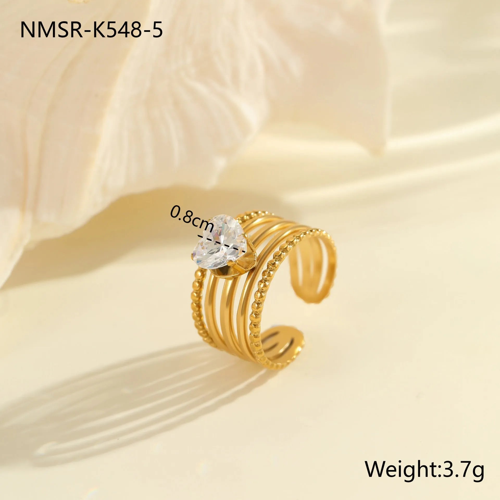 Gold electroplated adjustable ring with geometric zircon design on a stainless steel band.