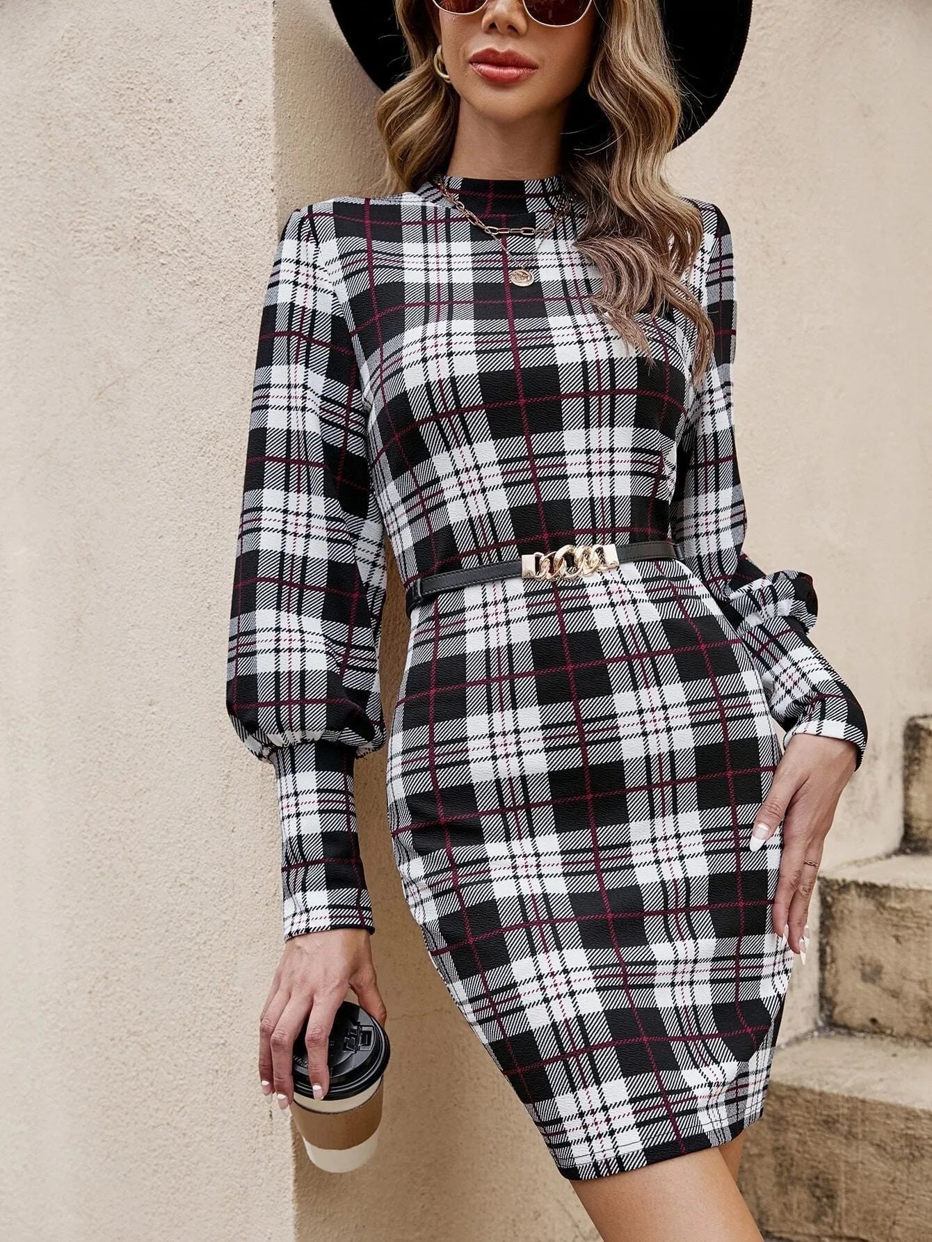 Black women's tight dress with lantern sleeves and leather stitching detail.