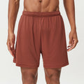 Men's quick-dry double-layer running shorts in a brick red colour on a mid-waist fit model.
