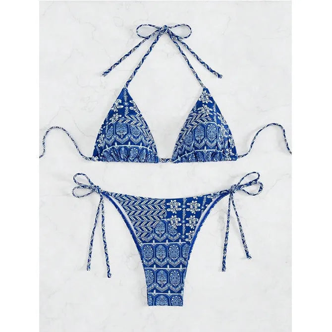 Women's green split bikini swimsuit with bandage-style stitching on a beach.