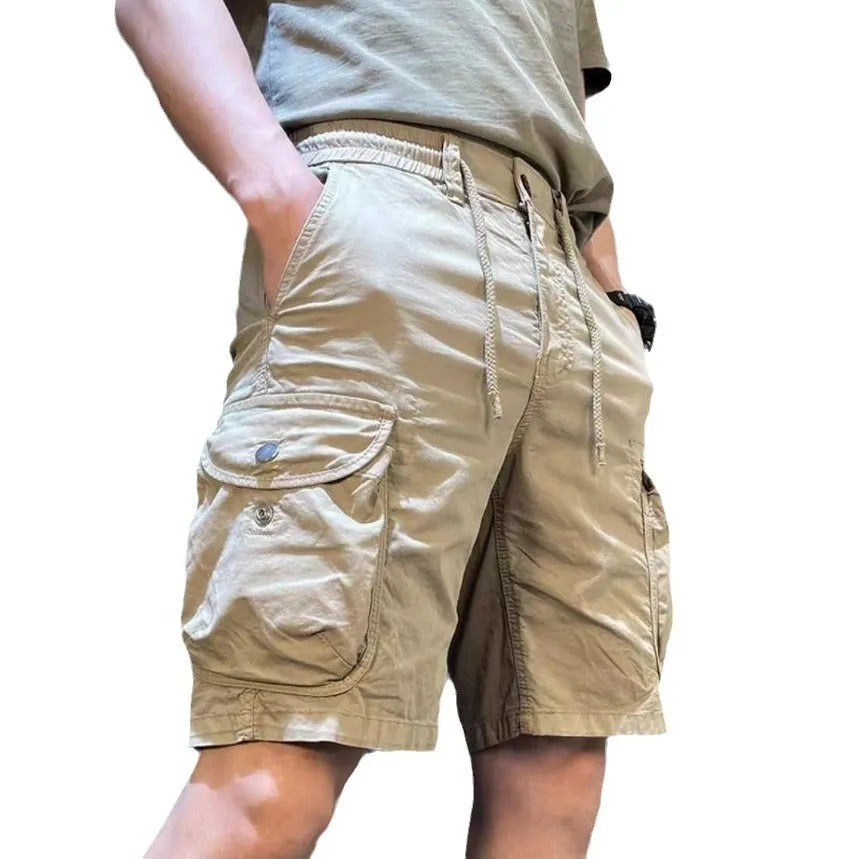 Loose straight-leg casual overalls with multiple cargo pockets in khaki, showing elastic waist and cropped length.