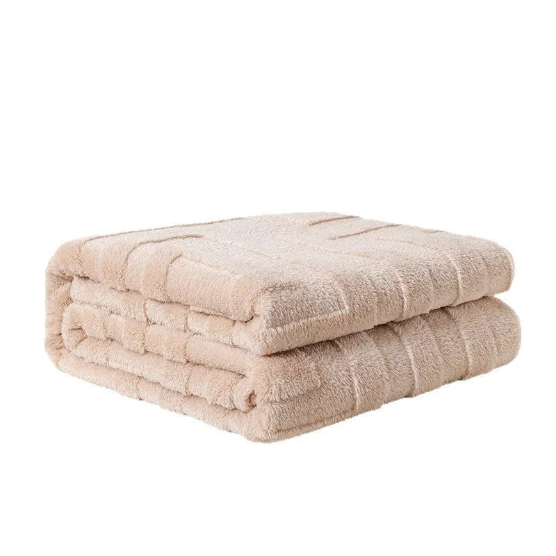 Thick square coral fleece flannel blanket in a solid colour, folded on a sofa.