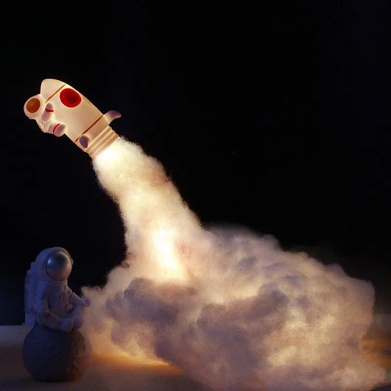 DIY astronaut rocket night light kit components including rocket model, LED lights, straws, and chassis on a desk.