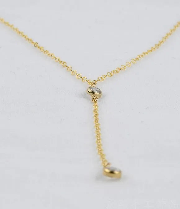 Gold alloy snake bone chain necklace with geometric pendant on display