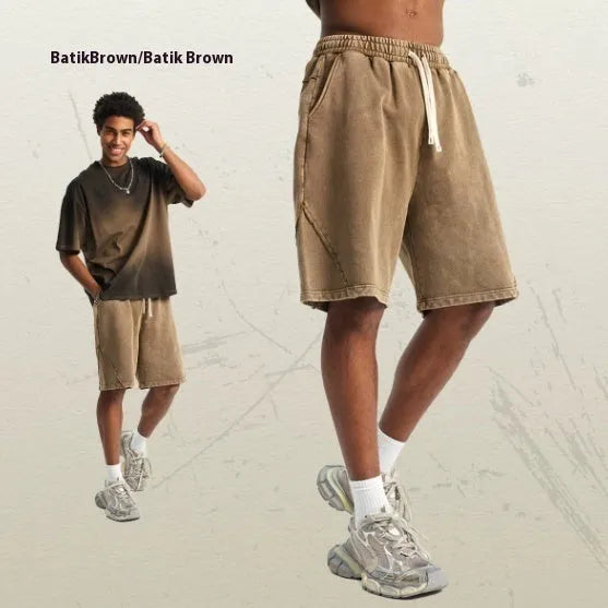 Man wearing batik pattern cotton terry shorts in a loose street fashion cut