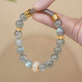 Grey moonstone women's bracelet with 8mm round beads on a wrist.