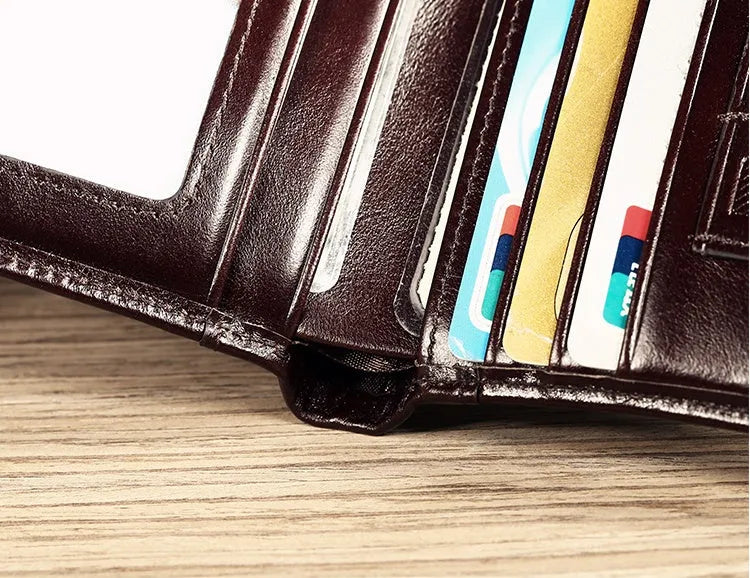Men's black full-grain leather bifold wallet open, showing card slots, zip coin pocket, and banknote section.