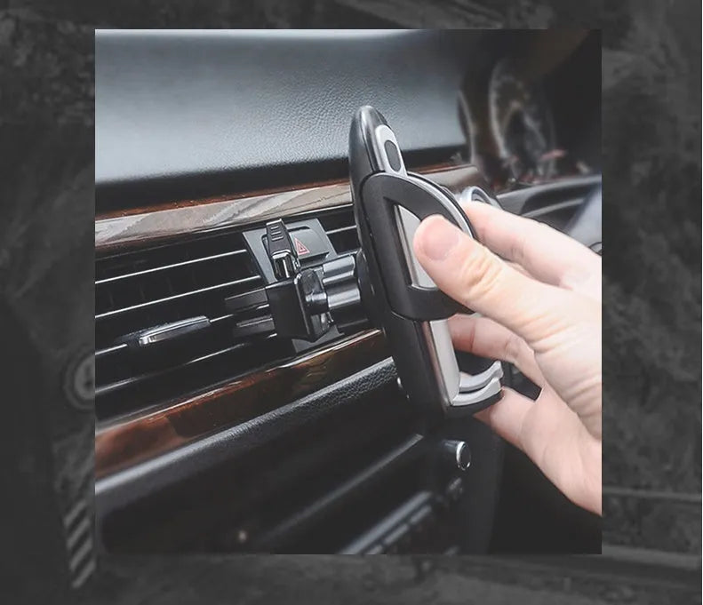 Black plastic car air vent phone holder attached to vehicle air conditioning outlet with mobile phone secured