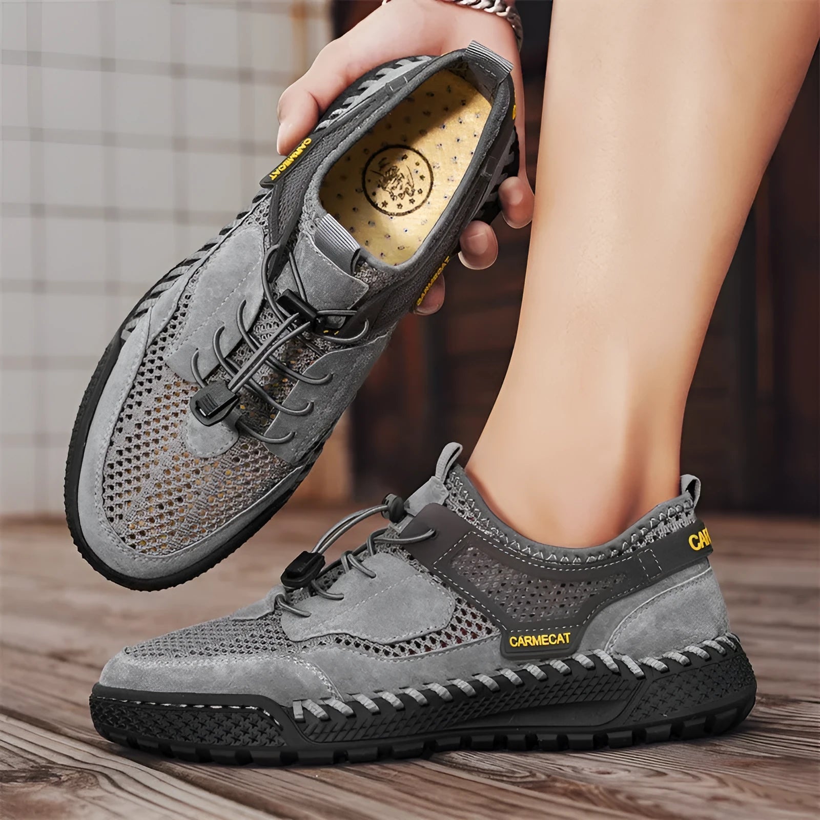 Men's brown suede tennis shoes with elastic band closure and hand-stitched rubber soles