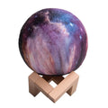 3D-printed spherical moon night light glowing with colour-changing LEDs on a dark surface.