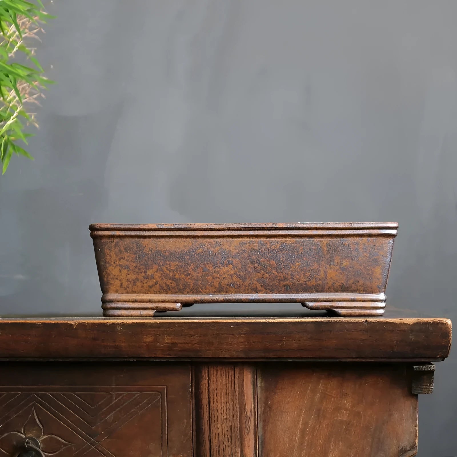 Handmade rectangular purple sand bonsai pot with natural firewood-burnt glaze, shown empty on a wooden surface.