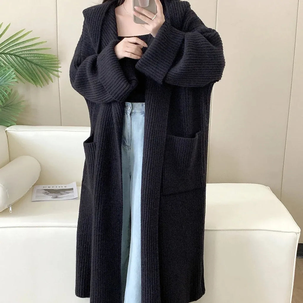A woman wearing a loose, milky white hooded cardigan coat with raglan sleeves.