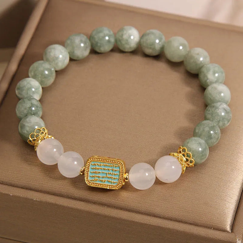 Women's oil green emerald crystal bracelet with five-piece sutra design on wrist.
